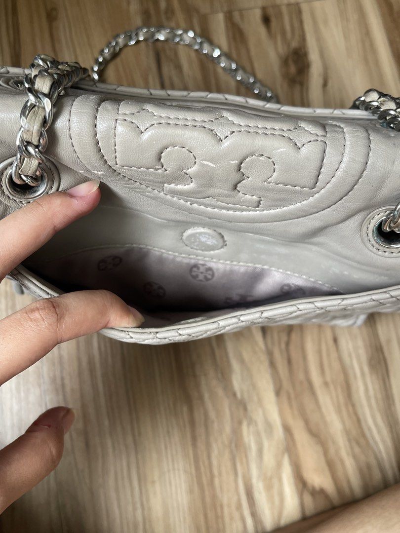 Tory Burch Convertible Shoulder Bag Grey Leather (Category: Luxury Bags & Wallets) located in Manila. Submitted by cosmicrabbit-9e5b (Listing ID 1449353371, Image 2). Description: - Grey leather Tory Burch Kira bag - Quilted chevron design - Silver chain strap - Magnetic snap closure - Interior zip and slip pockets - Fits a book - Minor signs of wear on zipper and hardware.