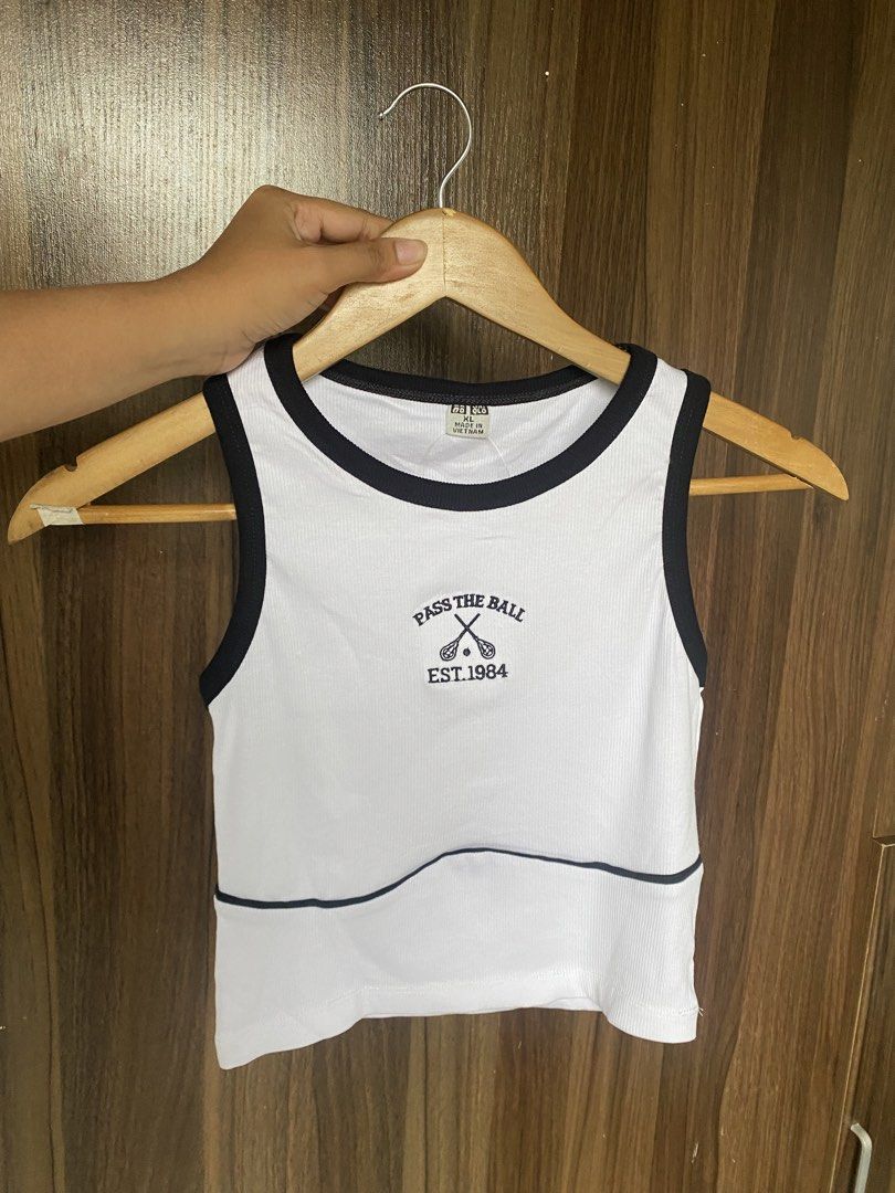 Uniqlo (Tank tops) (Category: Sleeveless) located in Cavite. Submitted by jaydaascollection (Listing ID 1449419231, Image 2). Description: - Cute cropped tank tops from UNIQLO - Ribbed material with contrast trim - Available designs: 'PASS THE BALL EST. 1984', 'LET'S RALLY' - Available colors: white, cream, grey, navy, brown, dusty rose, light green - Comfortable and stylish for casual wear or layering.