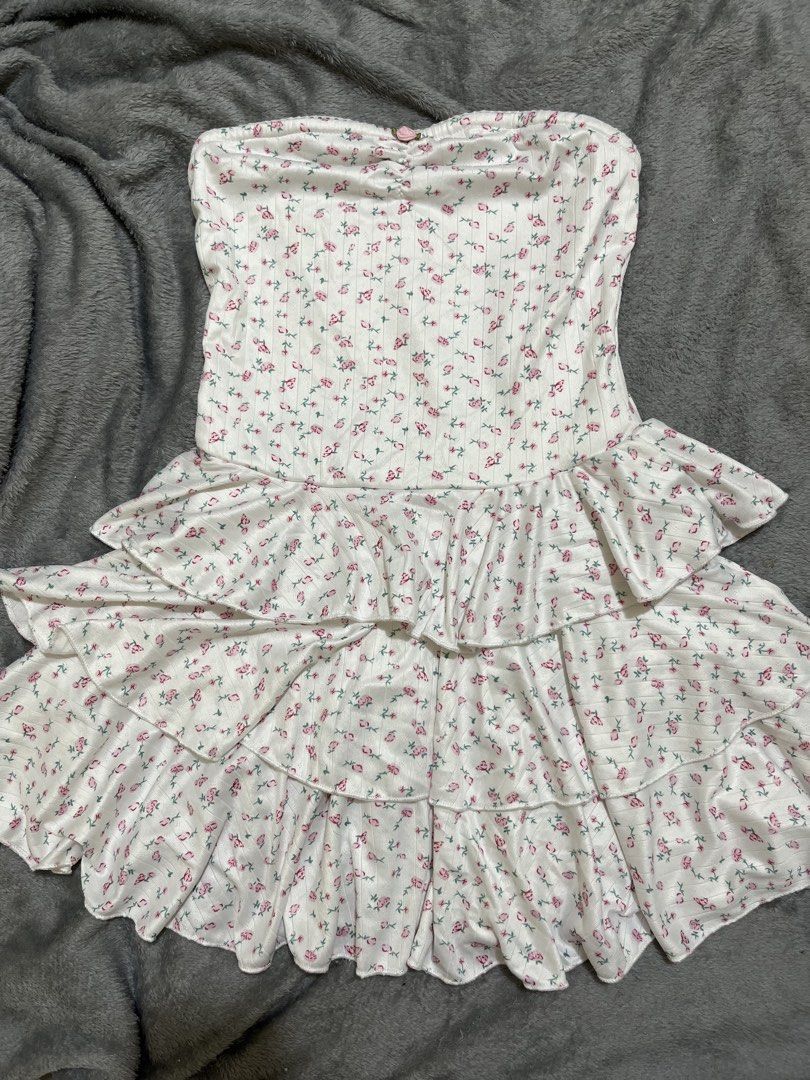 White Floral Tiered Strapless Mini Dress (Category: Dresses) located in Calauan. Submitted by emyelgi (Listing ID 1449334836, Image 2). Description: - White strapless mini dress - Pink floral print - Ribbed bodice - Tiered, ruffled skirt - Ruffled hemline - Estimated size: Small to Medium - Ideal for summer days or casual parties.