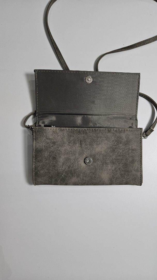 Y’s Yohji Yamamoto Wallet (Category: Luxury Bags & Wallets) located in Alfonso. Submitted by jbcamet (Listing ID 1449488824, Image 3). Description: - Chic grey wallet with distinct YS logo - Versatile long strap for crossbody wear - Interior includes multiple card slots for easy access - Secure zippered compartment for coins or small items - Front snap closure for added security - Ideal for keeping your essentials organized while on the move.