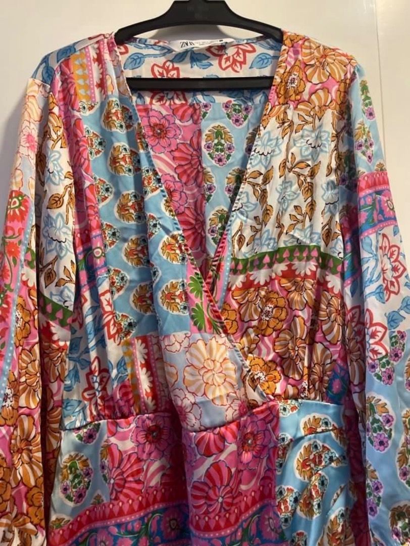 ZARA Patchwork Floral Wrap Dress Size L (Category: Dresses) located in Santiago. Submitted by hannahelish582 (Listing ID 1449347390, Image 2). Description: - Vibrant patchwork floral print - Flattering wrap style - Long sleeves - Made in Morocco - Size: L - Ideal for a statement look.