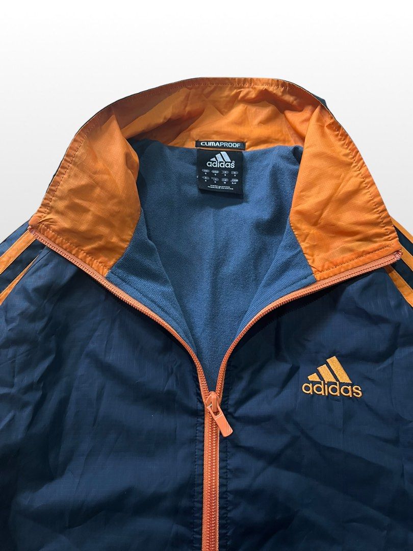 ADIDAS CLIMAPROOF WINDBREAKER JACKET (Category: Coats, Jackets and Outerwear) located in Valencia. Submitted by hunterxthrifter (Listing ID 1449658756, Image 3). Description: GOOD AS NEW Y2K STYLE SIZE LARGE LIGHT WEIGHT NAVY BLUE COLOR WAY AND ORANGE W-23.5 L-28.5.