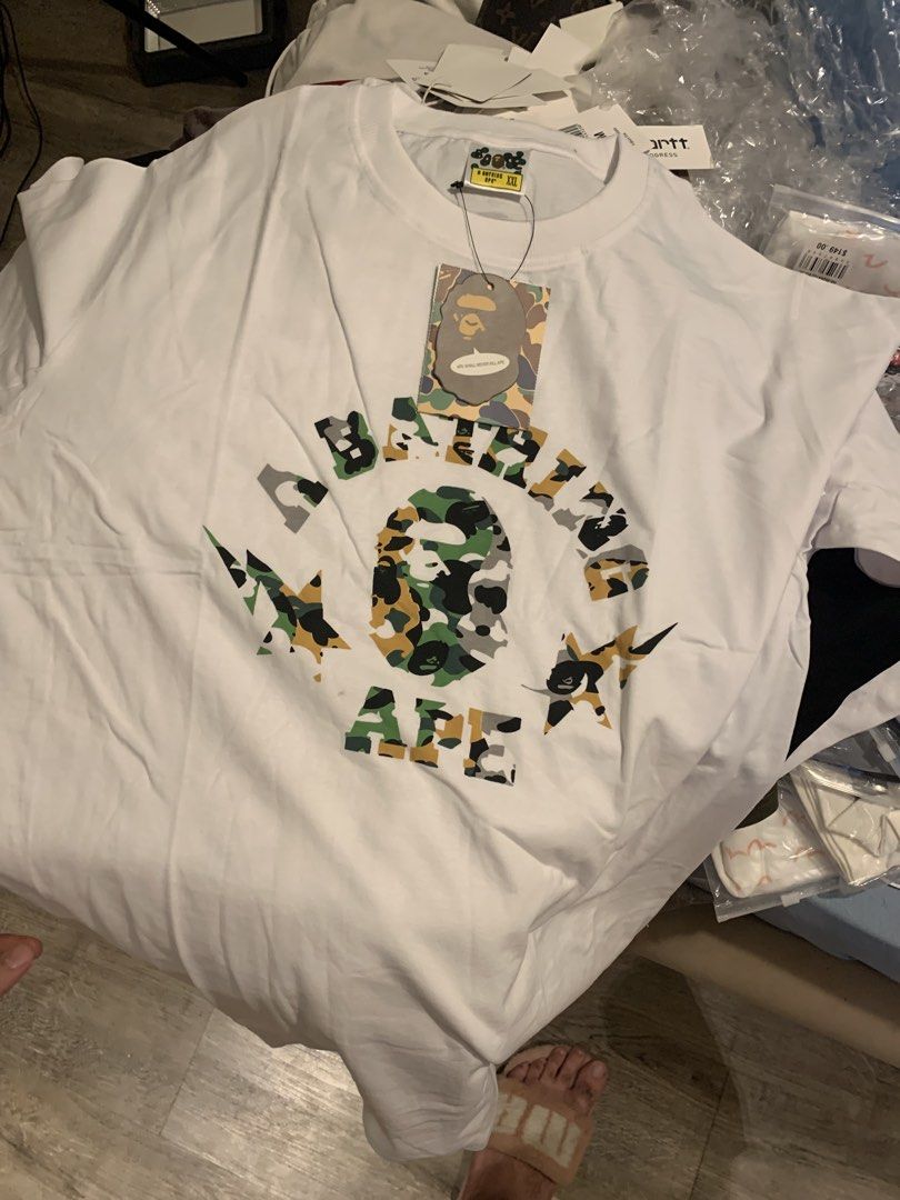 BAPE ABC Camo College Tee White (Category: Tshirts & Polo Shirts ) located in Manila. Submitted by vintaurafindsco. (Listing ID 1449538932, Image 1). Description: - Authentic White BAPE T-Shirt - Size: XXL - Features iconic ABC Camo College logo - Includes the classic ape head graphic - Brand new with original tags attached - Essential addition to any streetwear collection.