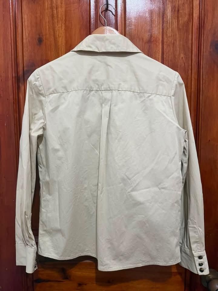 ba&sh Beige Utility Shirt with Double Pockets (Category: Tshirts & Polo Shirts ) located in Taguig. Submitted by geestuff27 (Listing ID 1449587038, Image 2). Description: - Brand: ba&sh - Color: Beige - Style: Utility shirt - Features: Two chest pockets with flap and button closure, button-down front, buttoned cuffs, shoulder epaulets - Look: Casual to smart-casual - Versatility: A great addition to any wardrobe.