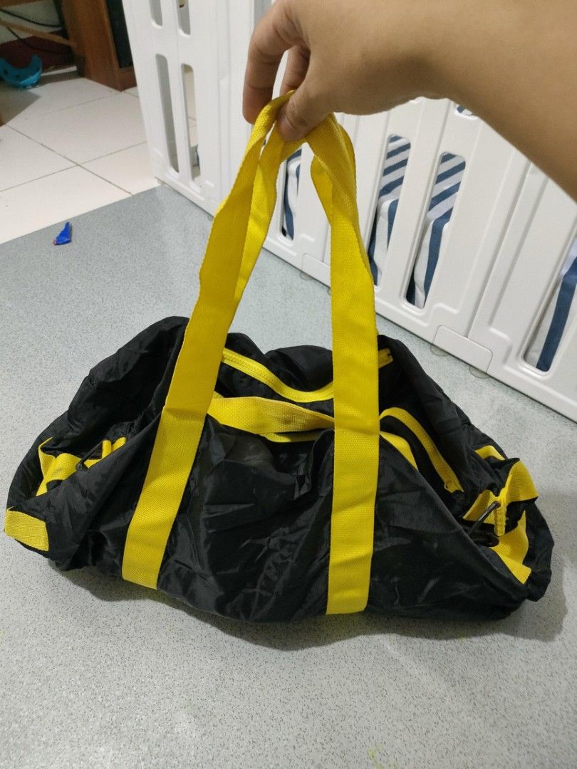 Black and Yellow Duffel Bag (Category: Shoulder Bags) located in General Santos City (Dadiangas). Submitted by rjb21 (Listing ID 1449698699, Image 2). Description: - Stylish black travel bag with vibrant yellow accents. - Convenient dual handles for easy carrying. - Secure zipper closure to keep your belongings safe. - Extra front zipper pocket for quick access to essentials. - Ideal for gym sessions or short getaways. - Folds up small for conven