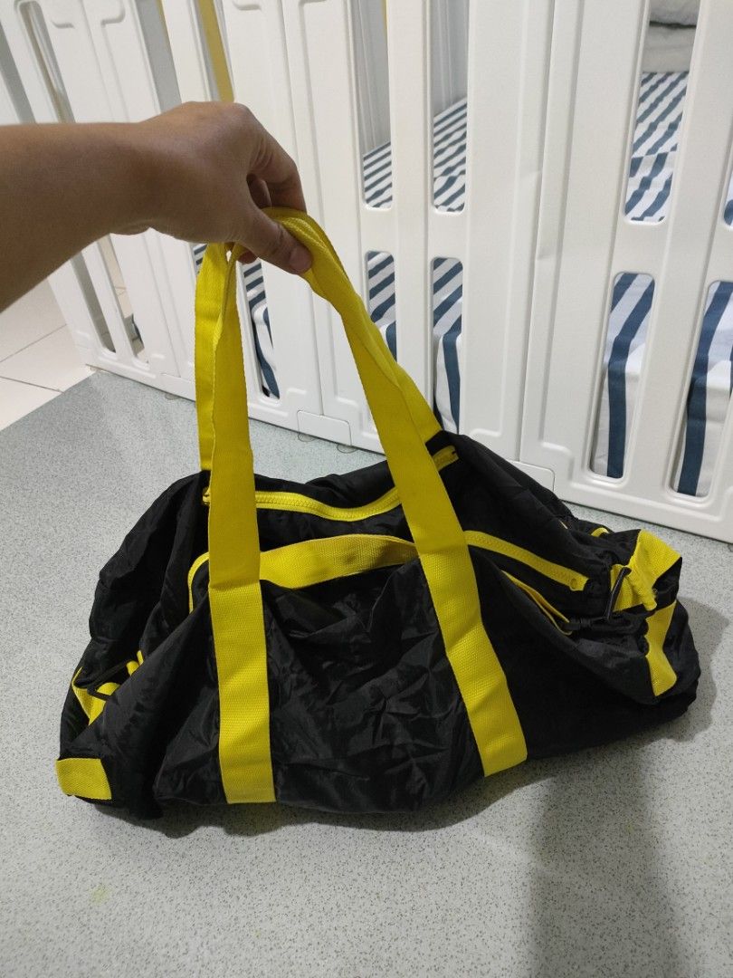 Black and Yellow Duffel Bag (Category: Shoulder Bags) located in General Santos City (Dadiangas). Submitted by rjb21 (Listing ID 1449698699, Image 3). Description: - Stylish black travel bag with vibrant yellow accents. - Convenient dual handles for easy carrying. - Secure zipper closure to keep your belongings safe. - Extra front zipper pocket for quick access to essentials. - Ideal for gym sessions or short getaways. - Folds up small for conven