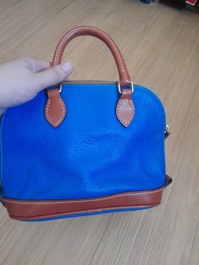 Dooney & Bourke Blue Leather Satchel Handbag (Category: Luxury Bags & Wallets) located in Angeles City. Submitted by declutterhub (Listing ID 1449651506, Image 2). Description: Classic blue leather satchel with brown trim. Features top handles, detachable strap, zip closure, and interior pockets. Gold-tone hardware. small size..