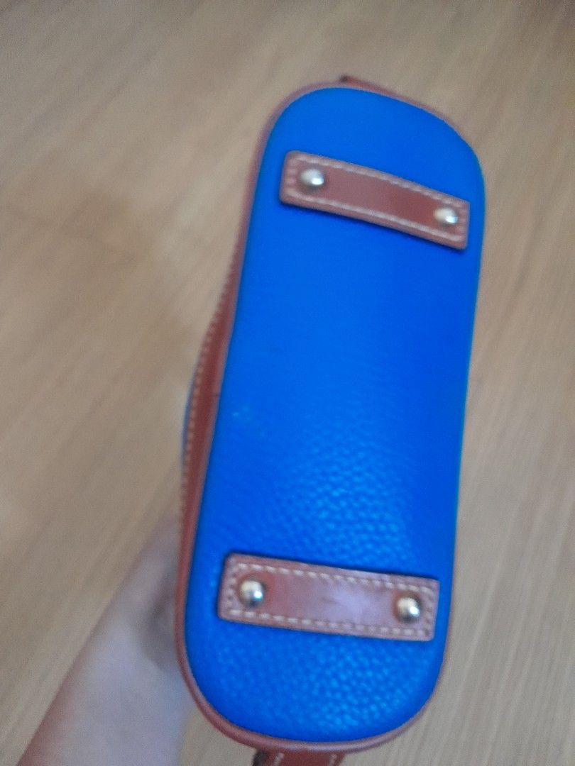 Dooney & Bourke Blue Leather Satchel Handbag (Category: Luxury Bags & Wallets) located in Angeles City. Submitted by declutterhub (Listing ID 1449651506, Image 3). Description: Classic blue leather satchel with brown trim. Features top handles, detachable strap, zip closure, and interior pockets. Gold-tone hardware. small size..