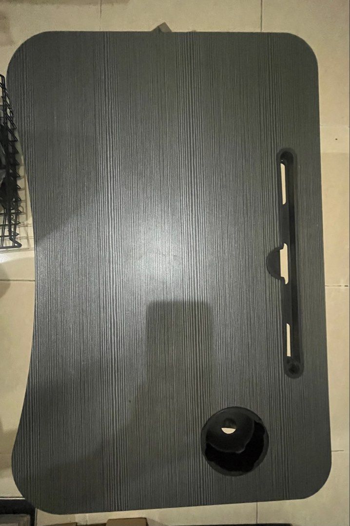 Foldable Table (Category: Tables & Sets) located in Bangi. Submitted by ainshukri (Listing ID 1449603049, Image 1). Description: - Portable laptop table, ideal for bed use. - Built-in cup holder and tablet/phone slot. - Legs fold flat for convenient storage. - Stylish dark wood grain finish. - Space-saving design, perfect for small homes..