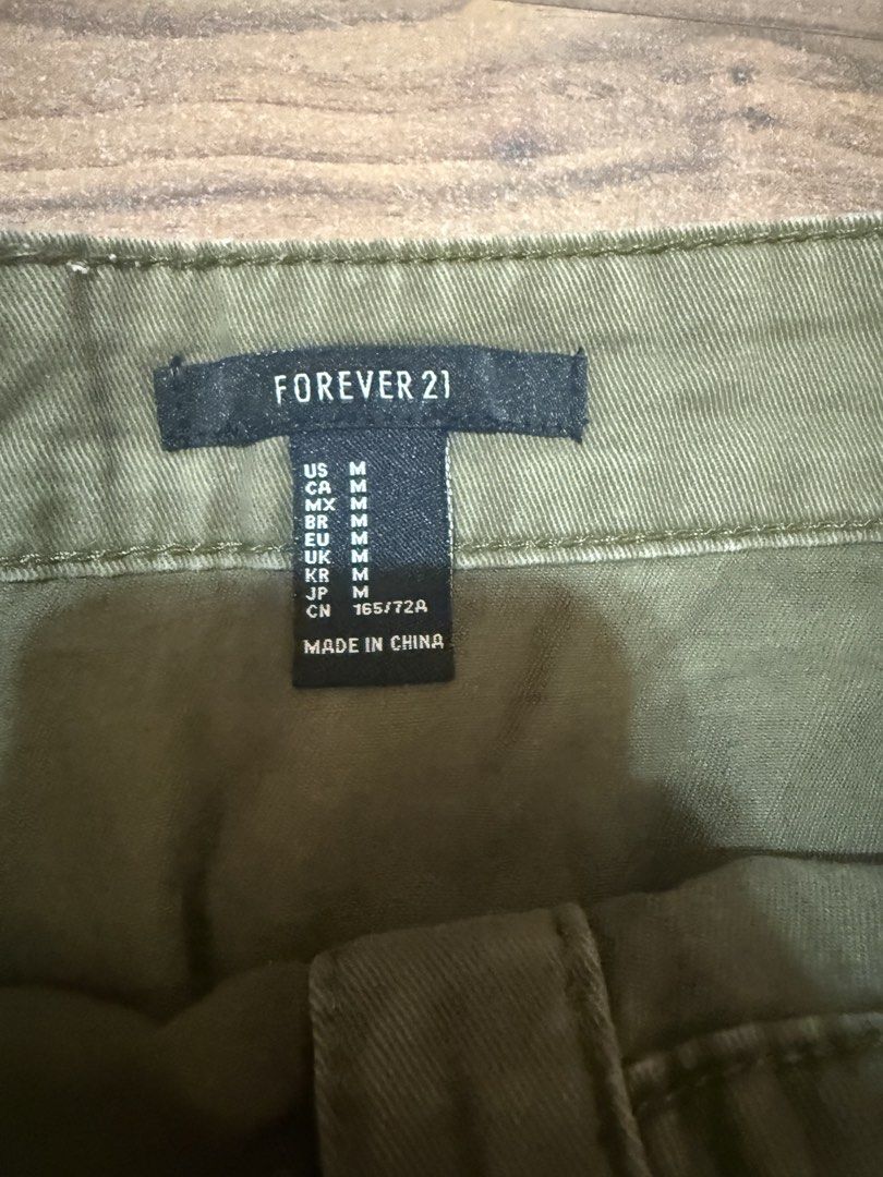 Forever 21 Olive Green Button-Front Utility Skirt Size M (Category: Skirts) located in Quezon City. Submitted by bpcloset (Listing ID 1449533982, Image 2). Description: - Olive green utility skirt - Brand: Forever 21 - Closure: Button-front - Features: Two front pockets - Size: Medium - Style: Casual, versatile.