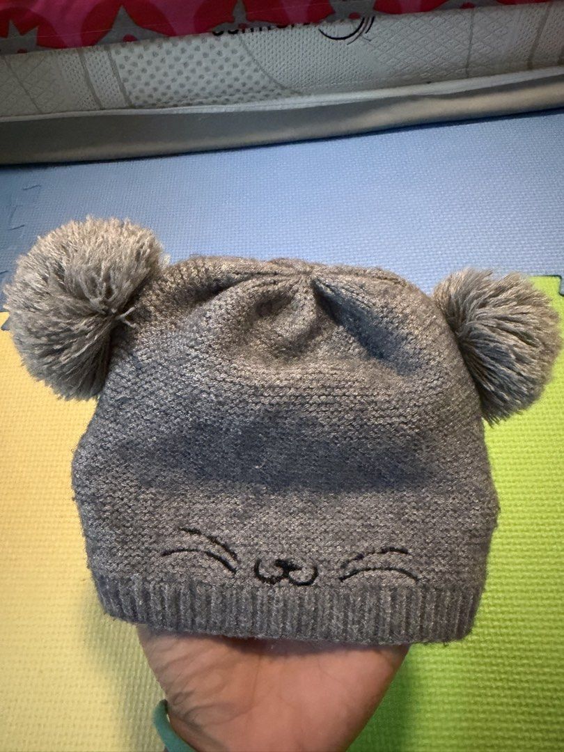 Grey Knit Cat Beanie with Pom Poms (Category: Hats & Beanies) located in Carmona. Submitted by reyamee (Listing ID 1449734613, Image 3). Description: - Adorable grey knit beanie for babies - Features cute pom pom ears - Sweet embroidered cat face design - Made from soft and stretchy knit material - Keeps little ones warm and stylish - Ideal for everyday wear or photos - Easy to put on and take off.
