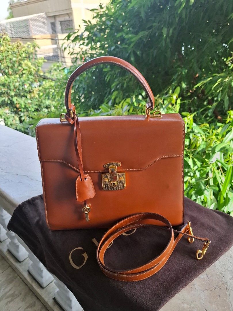 Gucci Brown Leather Top Handle Bag with Strap (Category: Luxury Bags & Wallets) located in Del Monte. Submitted by silvertree_520244 (Listing ID 1449612114, Image 1). Description: - Classic brown leather handbag - Top handle and detachable shoulder strap - Elegant gold hardware details - Interior zippered pocket and slip pocket - Comes with a dust bag.