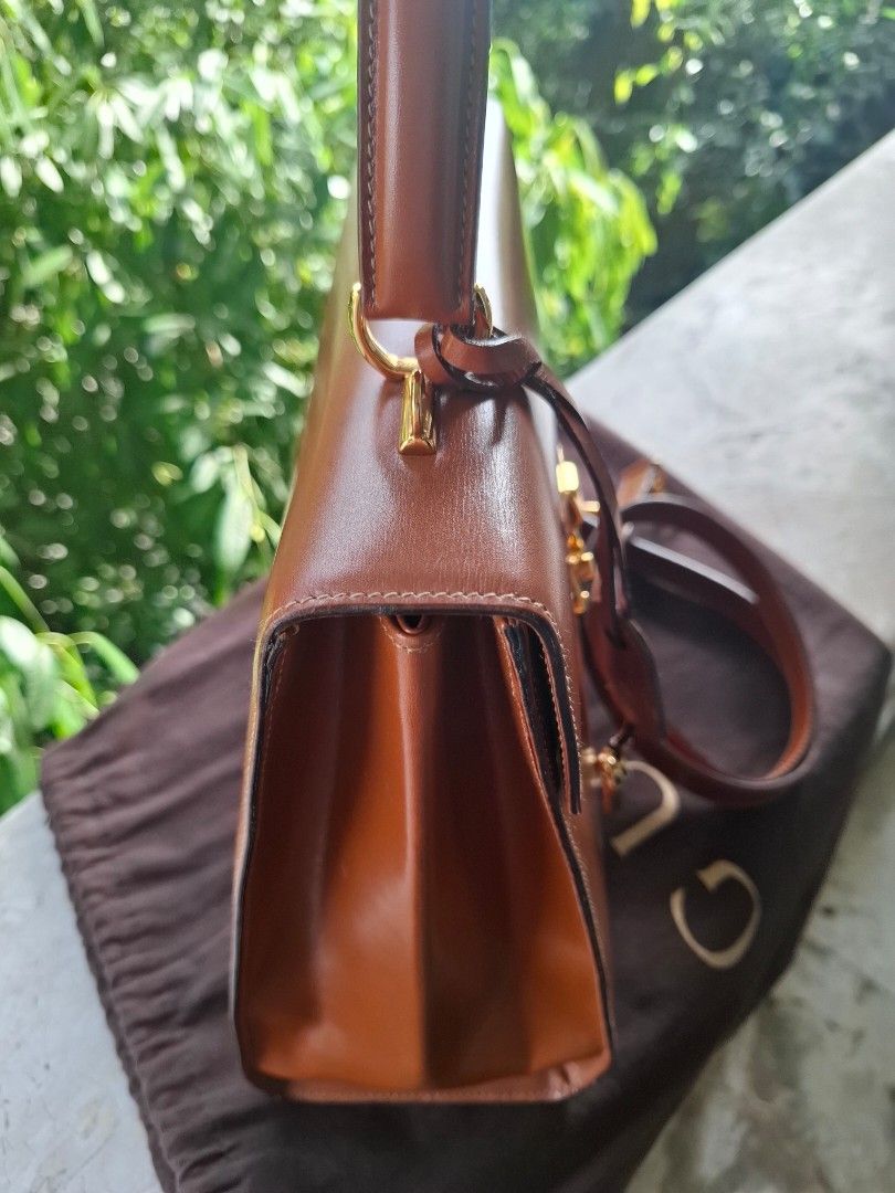 Gucci Brown Leather Top Handle Bag with Strap (Category: Luxury Bags & Wallets) located in Del Monte. Submitted by silvertree_520244 (Listing ID 1449612114, Image 2). Description: - Classic brown leather handbag - Top handle and detachable shoulder strap - Elegant gold hardware details - Interior zippered pocket and slip pocket - Comes with a dust bag.