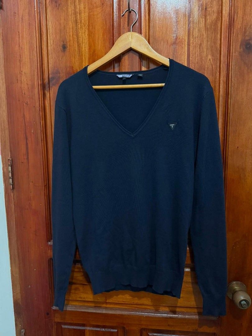 Guess Navy Blue V-Neck Sweater Size M (Category: Coats, Jackets and Outerwear) located in Taguig. Submitted by geestuff27 (Listing ID 1449582240, Image 1). Description: - Navy blue Guess sweater - V-neck style - Guess triangle logo on chest - Size: Medium (M) - Made in China - Versatile: great for layering or wearing on its own.