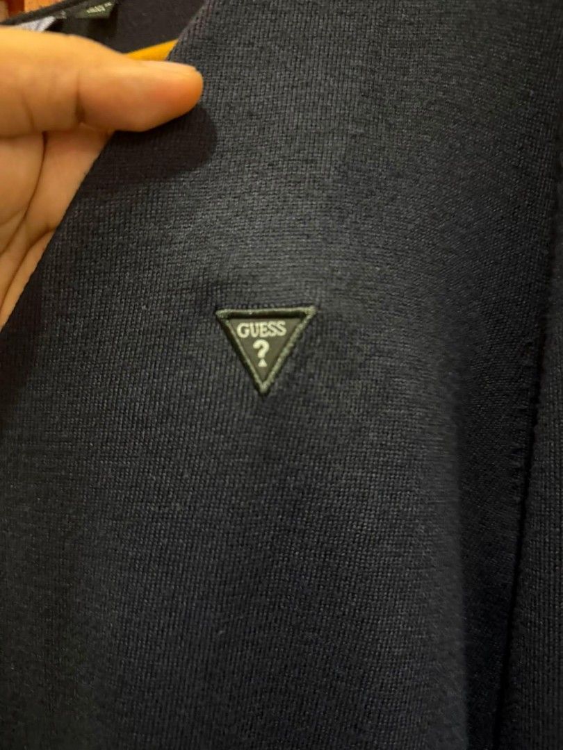 Guess Navy Blue V-Neck Sweater Size M (Category: Coats, Jackets and Outerwear) located in Taguig. Submitted by geestuff27 (Listing ID 1449582240, Image 3). Description: - Navy blue Guess sweater - V-neck style - Guess triangle logo on chest - Size: Medium (M) - Made in China - Versatile: great for layering or wearing on its own.