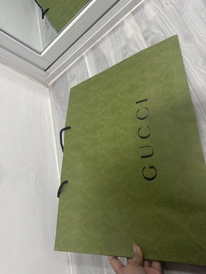 Large Gucci Paper Bag (48cm x 36 cm) (Category: Luxury Bags & Wallets) located in Manila. Submitted by janeng_ba10fd (Listing ID 1449702096, Image 2). Description: - Authentic Gucci shopping bag - Color: Green with embossed pattern - Features rope handles - Dimensions: Approx. 15 inches wide x 12 inches tall - Condition: Clean inside and out, no rips or tears - Perfect for shopping or as a gift bag.