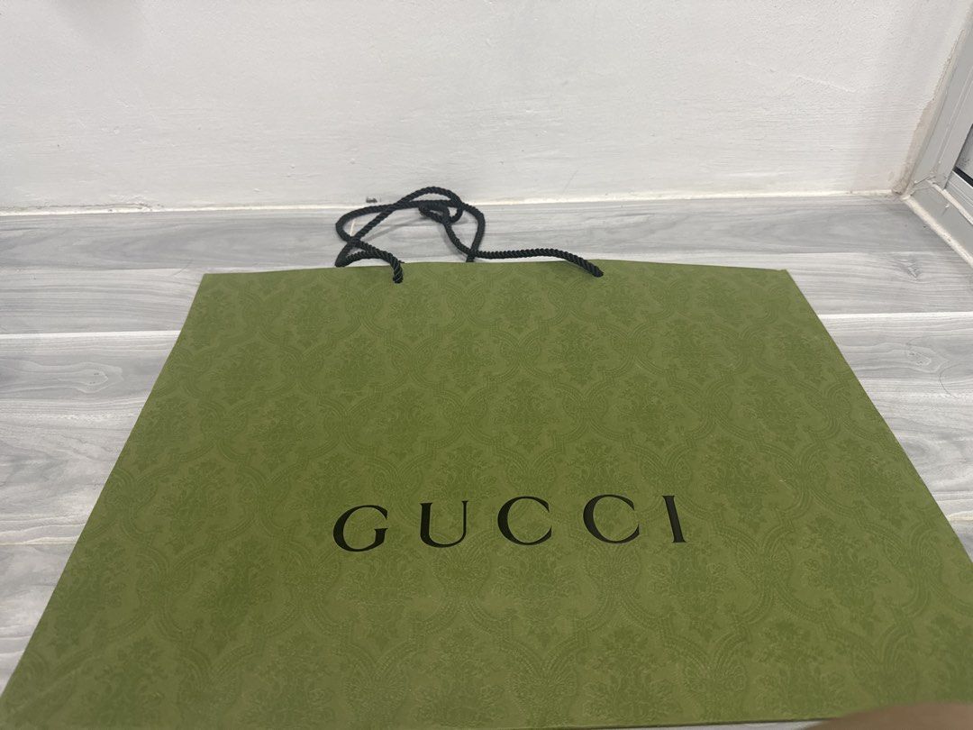 Large Gucci Paper Bag (48cm x 36 cm) (Category: Luxury Bags & Wallets) located in Manila. Submitted by janeng_ba10fd (Listing ID 1449702096, Image 1). Description: - Authentic Gucci shopping bag - Color: Green with embossed pattern - Features rope handles - Dimensions: Approx. 15 inches wide x 12 inches tall - Condition: Clean inside and out, no rips or tears - Perfect for shopping or as a gift bag.