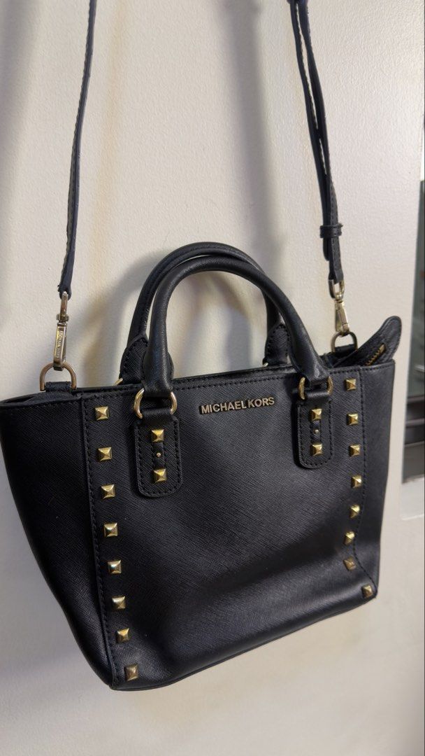 Michael Kors Black Studded Leather Satchel Bag (Category: Cross-body Bags) located in Paranaque City. Submitted by preluxeshop_ph (Listing ID 1449655787, Image 2). Description: Michael Kors Black Studded Leather Satchel Bag - Features elegant gold stud details on front and sides - Includes comfortable top handles - Comes with a detachable crossbody strap for versatile wear - Secure zipper closure - Interior boasts a zip pocket and multiple slip p
