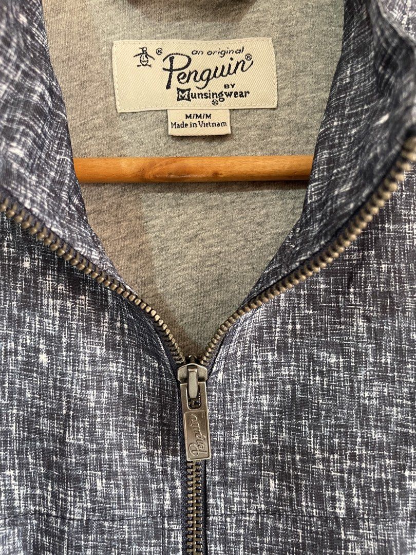 Original Penguin by Munsingwear Zip-Up Jacket (Category: Coats, Jackets and Outerwear) located in Mataasnakahoy. Submitted by zero4thrift (Listing ID 1449566419, Image 3). Description: - Original Penguin by Munsingwear jacket - Dark blue and white textured pattern - Full zip closure - Two side pockets - Ribbed cuffs and hem - Perfect for layering or light outerwear - Made in Vietnam - Size M Actual size - 22” width - 27” length - 24” sleeve .