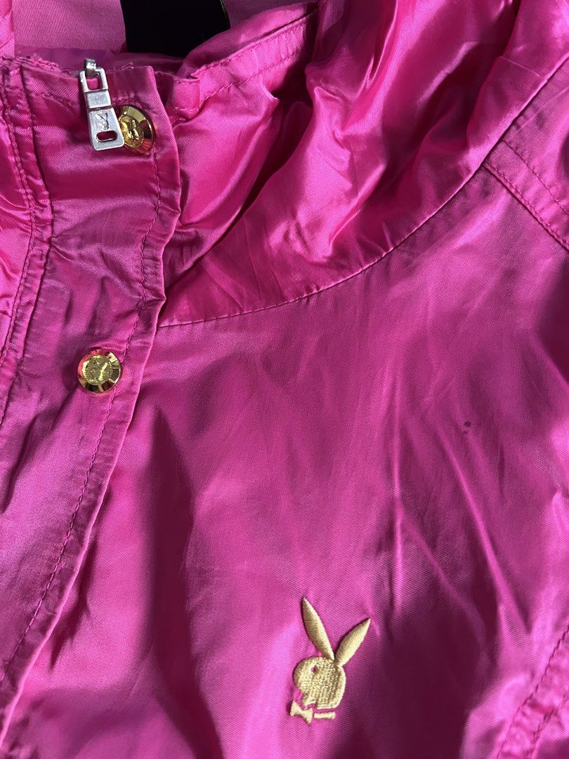 Playboy Physical Pink Windbreaker Jacket (Category: Coats, Jackets and Outerwear) located in Makati City. Submitted by annesexy (Listing ID 1449606820, Image 2). Description: - Pink Playboy windbreaker jacket - Features a hood - Stylish gold button details - Embroidered Playboy bunny logo on chest - Ideal for casual wear and light outdoor activities.