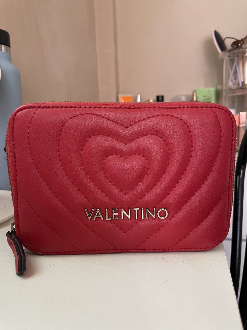 Red Valentino Heart Quilted Camera Bag (Category: Luxury Bags & Wallets) located in Baao. Submitted by closetbykb (Listing ID 1449556315, Image 1). Description: - Adorable red Valentino bag with a charming heart design. - Features a sleek silver chain strap. - Convenient zip pocket on the back for quick access. - Secure main zip compartment inside. - Interior includes a small leather tag with the Valentino logo. - Ideal size for carrying your dai