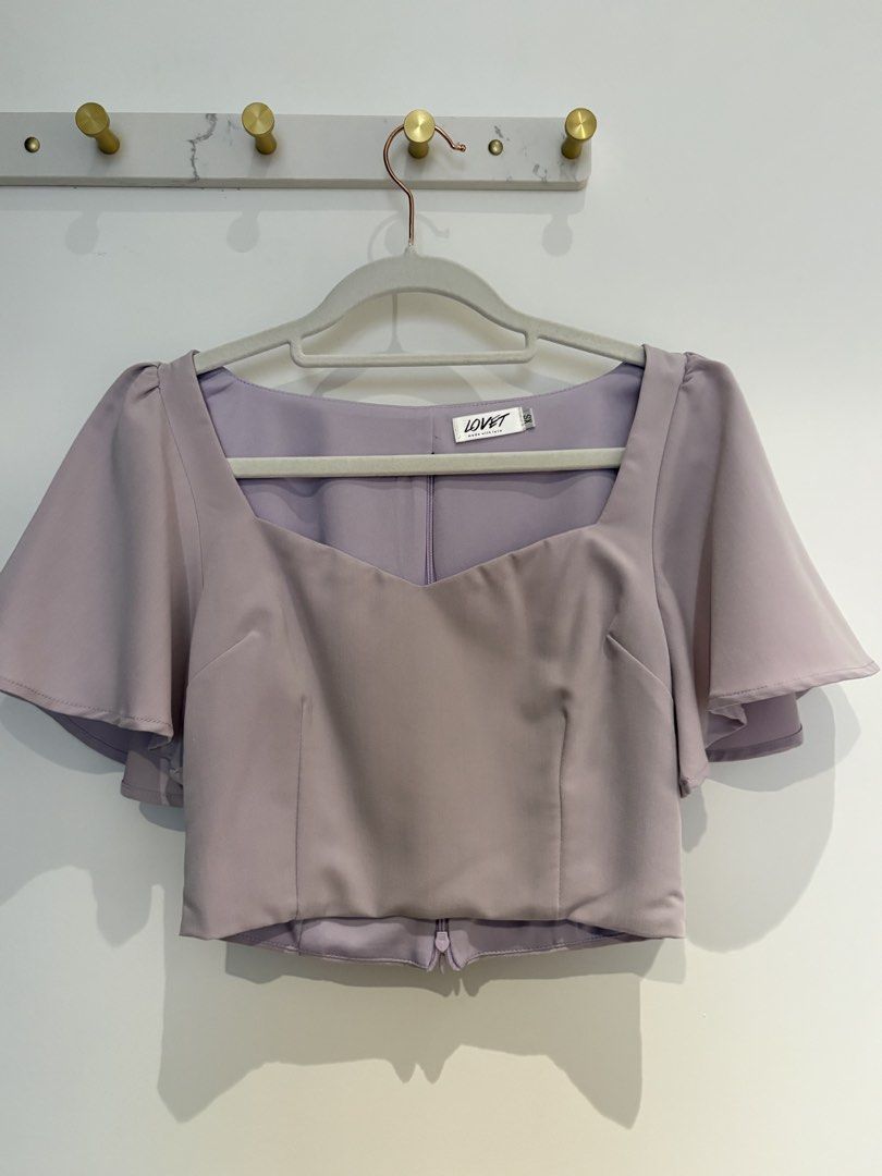 Lovet Lavender Sweetheart Neck Flutter Sleeve Crop Top (Category: Blouses) located in Kuala Lumpur. Submitted by emily.sfl (Listing ID 1449702423, Image 1). Description: - Brand: Lovet - Color: Lavender - Style: Crop top - Neckline: Sweetheart - Sleeves: Flutter sleeves - Closure: Back zipper - Estimated Size: XS - Occasion: Dress up or down.