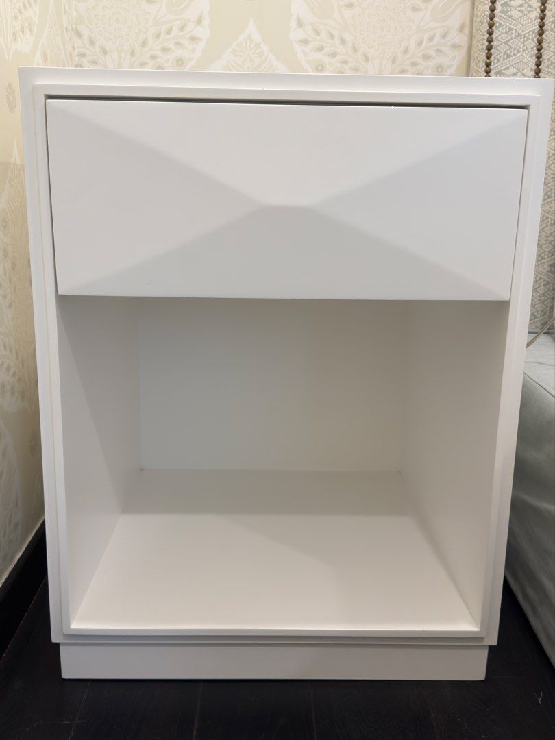 Side table (Category: Shelves, Cabinets & Racks) located in Singapore. Submitted by swifthawk_e22f09 (Listing ID 1449675555, Image 2). Description: - bedside table / night stand - spray painted white - Geometric drawer front, slow closing mechanism - Ample space for essentials - height: 64cm, breadth: 50cm, depth: 50cm (approx measurements) - there is a second piece with some markings available for lower price .