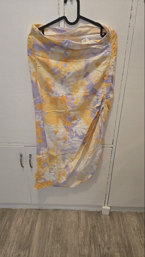 Stradivarius Tie Dye Ruched Midi Skirt (Category: Skirts) located in Manila. Submitted by xiaauma (Listing ID 1449637625, Image 1). Description: - Trendy tie-dye midi skirt - Vibrant yellow and purple floral print - Flattering ruched detail on the side - Chic wrap-style silhouette - Ideal for casual outings and beach days.