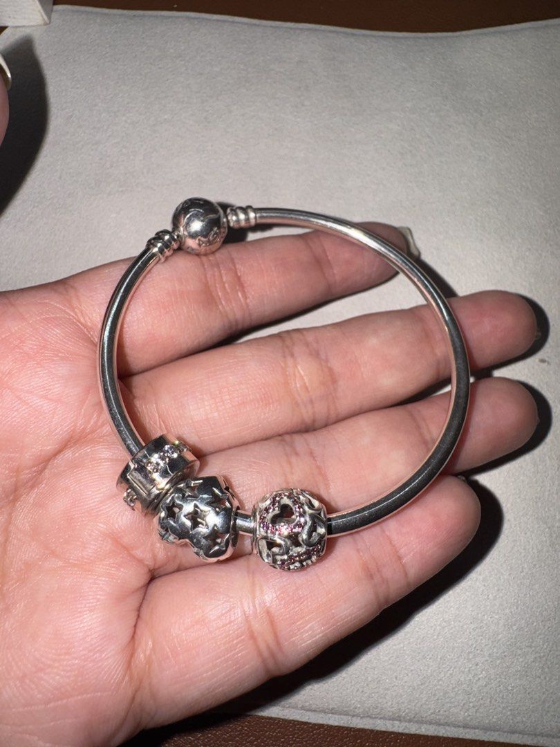 (TAKE ALL) Pandora bracelet with 3 charms (Category: Bracelets) located in Paranaque City. Submitted by nestore.clothing (Listing ID 1449732589, Image 2). Description: - Authentic Pandora sterling silver bangle bracelet - Includes 3 beautiful charms - Star design charm - Cubic zirconia charm - Patterned charm with pink stones Total price of this is around 10k+ .