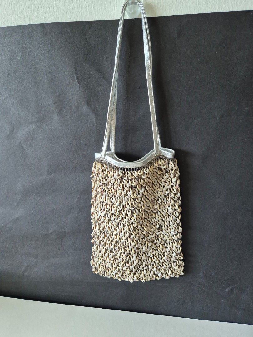 Tango Drawstring Pouch with Pattern (Category: Purses & Pouches) located in Singapore. Submitted by clunar (Listing ID 1449604747, Image 1). Description: - This Tango bag adorned with numerous small white seashells, with a thin silver shoulder strap - Includes a drawstring dark green pattern fabric bag, tag with 'TANGO' logo. - The fabric bag can be use as a drawstring bucket bag or dustbag when storing - Perfect for weekends, casual and stylish 