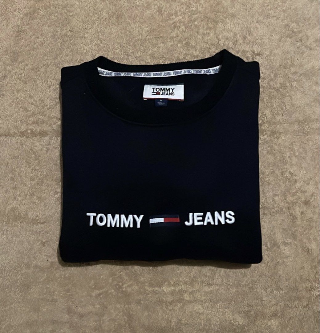 Tommy Jeans Black Sweatshirt Size M (Category: Coats, Jackets and Outerwear) located in Cebu City. Submitted by johnova18 (Listing ID 1449741431, Image 1). Description: Tommy Hilfiger Embroidered logo Black Sweater Authentic ✅ Size: Large( Medium on tag) Width: 22.5 Length: 28 Color rate: 10/10 Pristine condition Good As New 2000 + shipping fee Location: Cebu City.