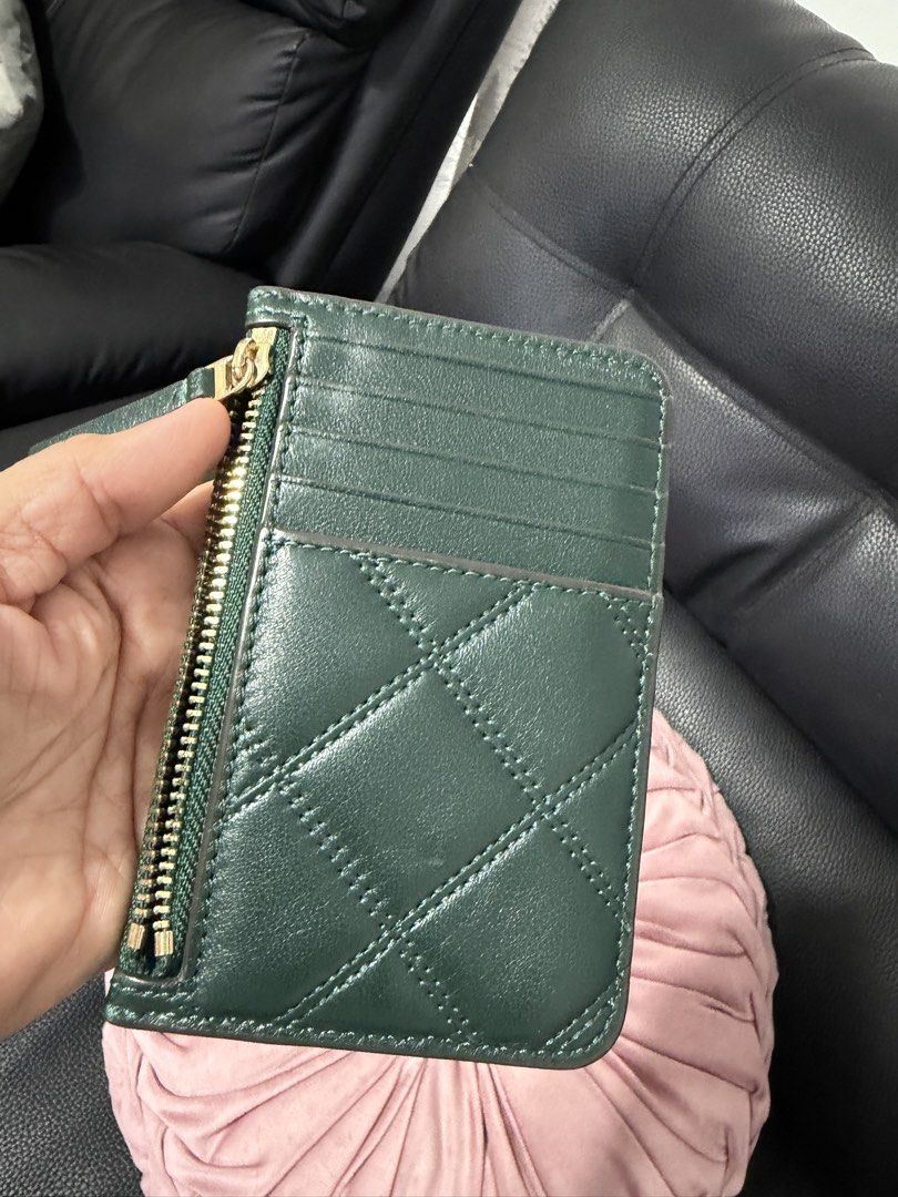 Tory Burch Quilted Card Holder Green (Category: Purses & Pouches) located in Mexico. Submitted by simang888 (Listing ID 1449571686, Image 3). Description: - Deep green Tory Burch card holder - Quilted front with signature Tory Burch logo - Zippered compartment for coins or small items - Multiple card slots on the back - Elegant gold hardware - Ideal for keeping cards and essentials organized.