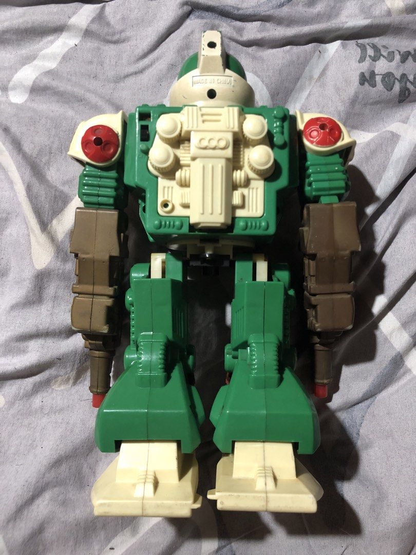 Vintage Green Robot Action Figure Toy (Category: Action & Battle Toys) located in Manila. Submitted by bakithrift213 (Listing ID 1449689821, Image 2). Description: - Cool vintage robot toy - Green and brown color scheme - Equipped with guns on its arms - Ideal for collectors or display purposes.