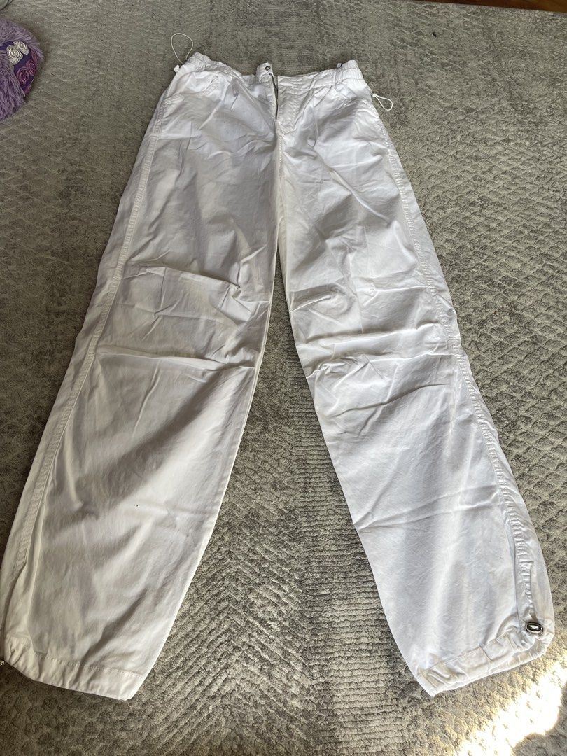 Bershka White Parachute Pants with Drawstring Ankles (Category: Other Bottoms) located in Manila. Submitted by shoptjg (Listing ID 1449796298, Image 1). Description: - White cargo pants - Wide leg style - Drawstring ankles - Side pockets - Elastic waistband with drawstring - Ideal for casual wear - Easy to style.