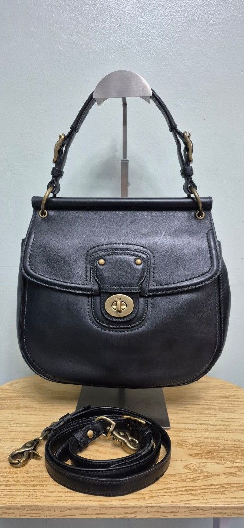 Black Leather Coach Saddle Bag with Strap (Category: Luxury Bags & Wallets) located in Manila. Submitted by shandarfa49055 (Listing ID 1449786537, Image 1). Description: Classic and timeless Coach leather bag in excellent pre-loved condition. Crafted from smooth black leather with antique brass hardware and Coach's signature turnlock closure. Features a spacious interior with striped fabric lining, interior zip pocket, top handle, and shoulder st