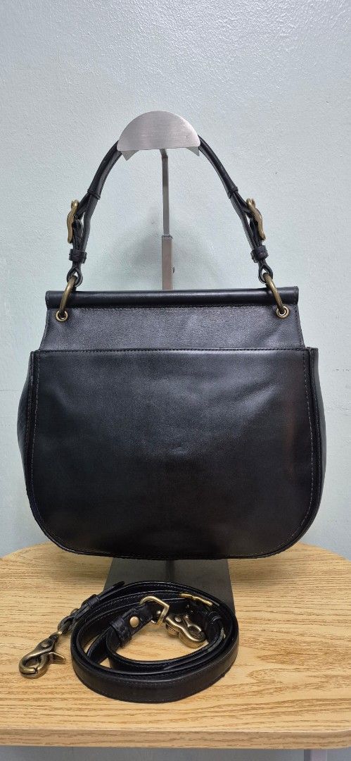 Black Leather Coach Saddle Bag with Strap (Category: Luxury Bags & Wallets) located in Manila. Submitted by shandarfa49055 (Listing ID 1449786537, Image 2). Description: Classic and timeless Coach leather bag in excellent pre-loved condition. Crafted from smooth black leather with antique brass hardware and Coach's signature turnlock closure. Features a spacious interior with striped fabric lining, interior zip pocket, top handle, and shoulder st