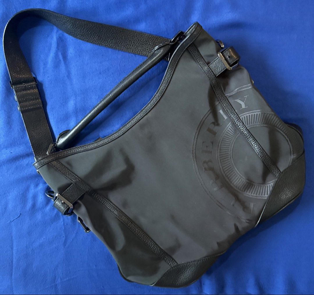 Burberry Nylon Leather Shoulder Bag (Category: Luxury Bags & Wallets) located in Marikina City. Submitted by all4bangtan (Listing ID 1449845764, Image 1). Description: - Authentic Burberry shoulder bag in classic black and dark purple - Crafted from high-quality nylon with elegant leather accents. - Distinctive Burberry logo embossed on the front for a touch of luxury. - Adjustable shoulder strap ensures a comfortable, customized fit. - A versati