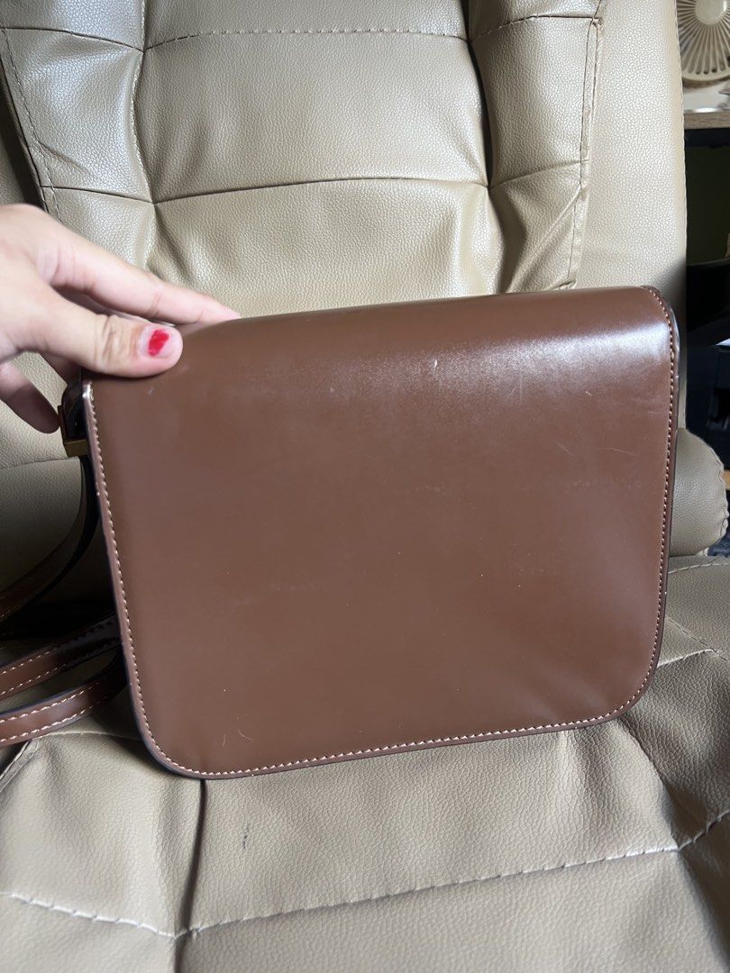 Celine Paris Brown Leather Crossbody Bag (Category: Cross-body Bags) located in Saravia. Submitted by clynlyn (Listing ID 1449853248, Image 3). Description: - Authentic Celine Paris brown leather crossbody bag - Elegant gold-tone clasp closure - Spacious main compartment with an interior zippered pocket - Adjustable strap for comfortable wear - Expertly crafted in Italy - Shows minor scuffs on the exterior, but remains in good overall condition.