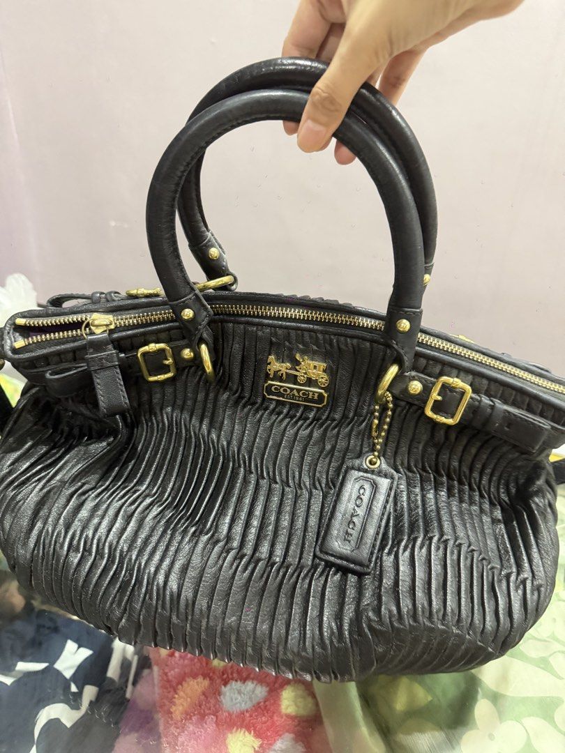 Coach Black Leather Gathered Satchel Bag (Category: Luxury Bags & Wallets) located in Cavite. Submitted by anna1033 (Listing ID 1449915295, Image 2). Description: - Genuine black leather Coach satchel bag - Elegant gathered detailing on front and sides - Polished gold-tone hardware throughout - Comfortable top handles - Includes a detachable shoulder strap for versatility - Luxurious purple satin interior lining - Secure zipper closure - Iconic C