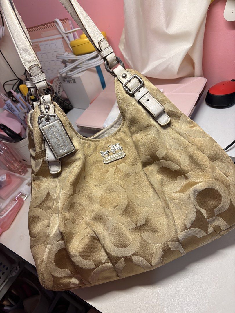 Coach Madison Maggie Op Art (Category: Luxury Bags & Wallets) located in Baguio. Submitted by declutterwithmako (Listing ID 1449827046, Image 1). Description: - Authentic Coach Hobo Bag - Classic beige and brown signature C pattern - Cream leather trim and straps - Silver hardware details - Spacious interior for essentials - Stylish everyday bag.