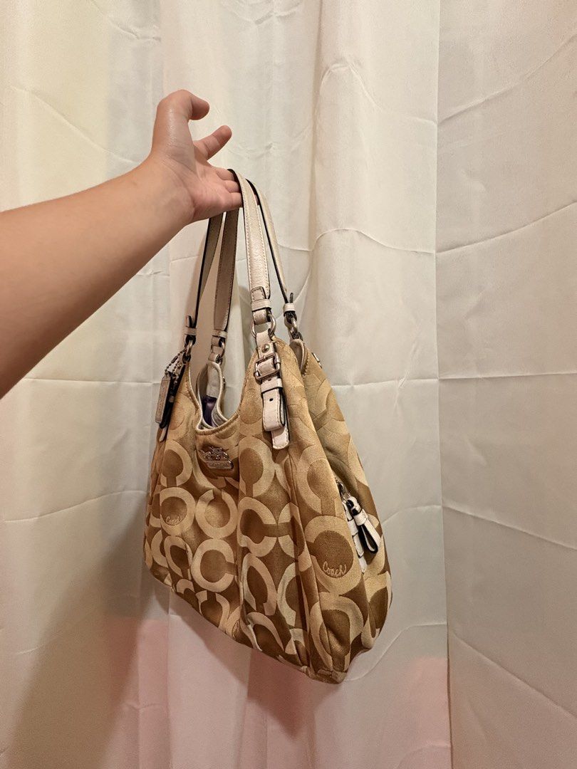 Coach Madison Maggie Op Art (Category: Luxury Bags & Wallets) located in Baguio. Submitted by declutterwithmako (Listing ID 1449827046, Image 3). Description: - Authentic Coach Hobo Bag - Classic beige and brown signature C pattern - Cream leather trim and straps - Silver hardware details - Spacious interior for essentials - Stylish everyday bag.