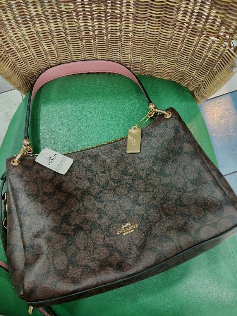 Coach Signature Monogram Brown Shoulder Bag (Category: Luxury Bags & Wallets) located in Manila. Submitted by macchi1216 (Listing ID 1449904782, Image 3). Description: - Authentic Coach shoulder bag - Signature monogram print in brown - Black straps and pink interior lining - Gold hardware details - Zipper closure - Comes with Coach tag and charm - with issue inside creed patch .