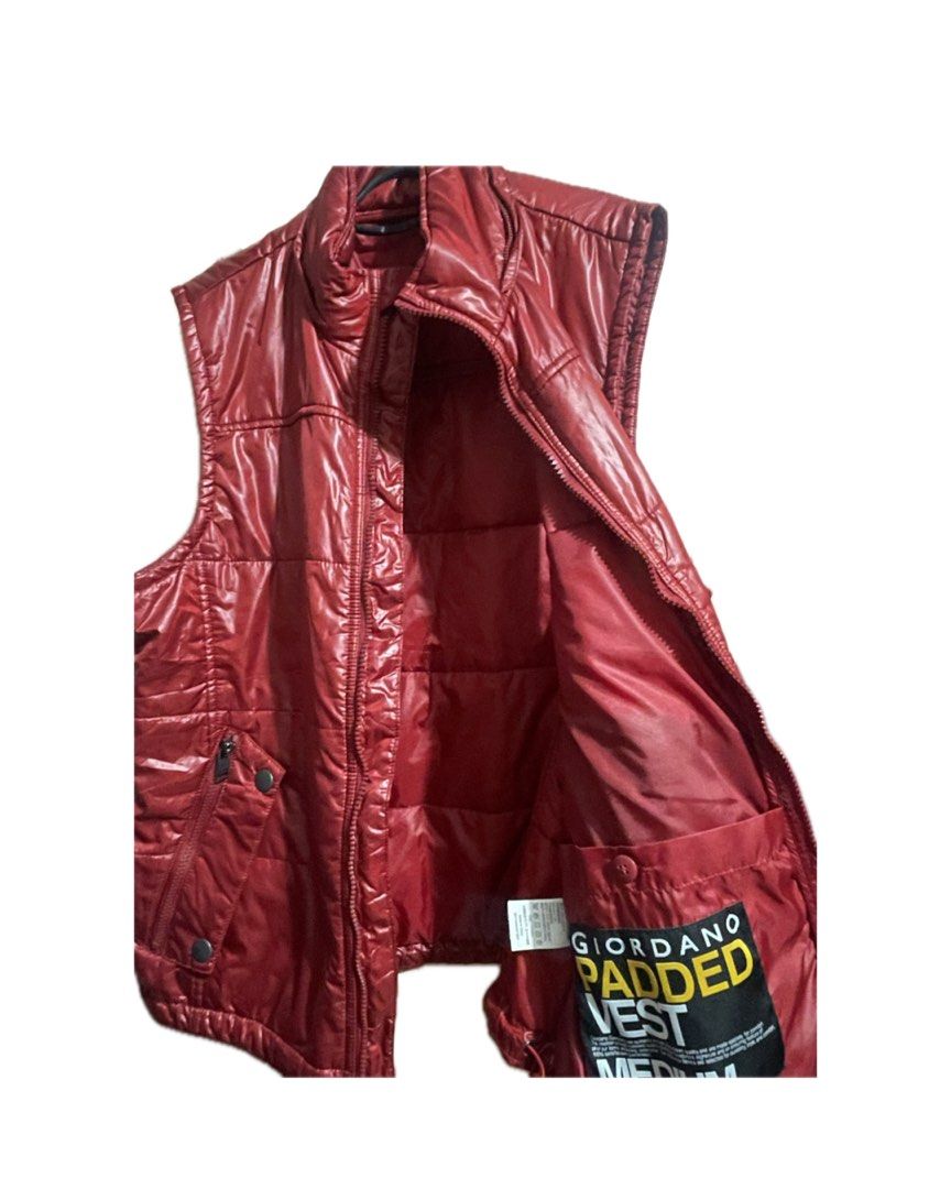 Giordano Padded Vest (Category: Coats, Jackets and Outerwear) located in Tarlac. Submitted by declutter.diaries. (Listing ID 1449875270, Image 3). Description: Exterior Material: A glossy, water-resistant nylon or polyester shell with horizontal puffer quilting. Front Closure: Full-length zipper matching the red color of the vest. Collar: High stand-up collar for wind protection. Pockets: Two slanted front hand pockets featuring both zipper closu
