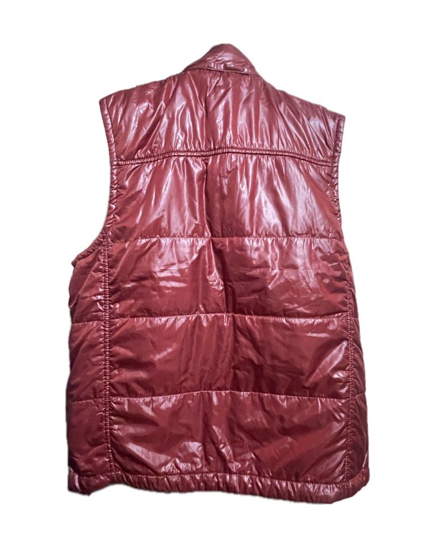 Giordano Padded Vest (Category: Coats, Jackets and Outerwear) located in Tarlac. Submitted by declutter.diaries. (Listing ID 1449875270, Image 2). Description: Exterior Material: A glossy, water-resistant nylon or polyester shell with horizontal puffer quilting. Front Closure: Full-length zipper matching the red color of the vest. Collar: High stand-up collar for wind protection. Pockets: Two slanted front hand pockets featuring both zipper closu
