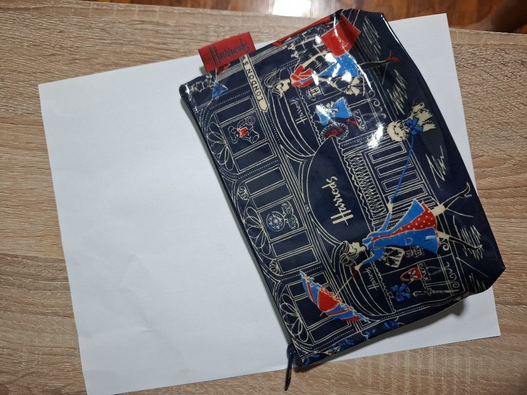 Harrods London Blue Cosmetic Pouch (Category: Purses & Pouches) located in Makati City. Submitted by itemsforless2025 (Listing ID 1449897743, Image 3). Description: - Cute Harrods pouch with a charming London scene print. - Features women shopping and iconic London landmarks. - Secure zip closure. -pvc material - Ideal for storing makeup or travel essentials. - Approximate dimensions: 8 inches wide x 5 inches tall. - Interior lining also features