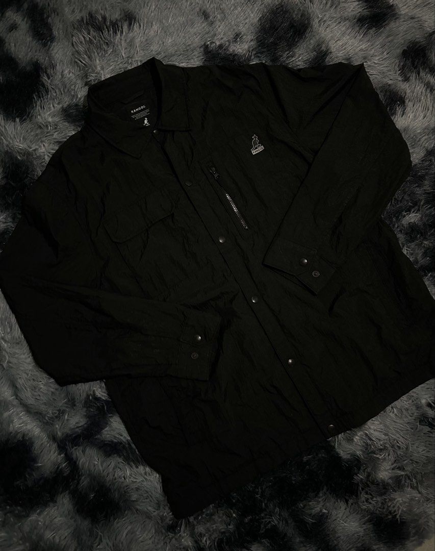Kangol Black Utility Jacket W23 L30 (Category: Coats, Jackets and Outerwear) located in Cadiz. Submitted by jaybatiller (Listing ID 1449814395, Image 3). Description: - Classic black coach jacket from Kangol - Button-up front with a collar - Two chest pockets - Zippered pocket on the left chest - Embroidered Kangol logo on the chest - Long sleeves with button cuffs - Simple and classic style.