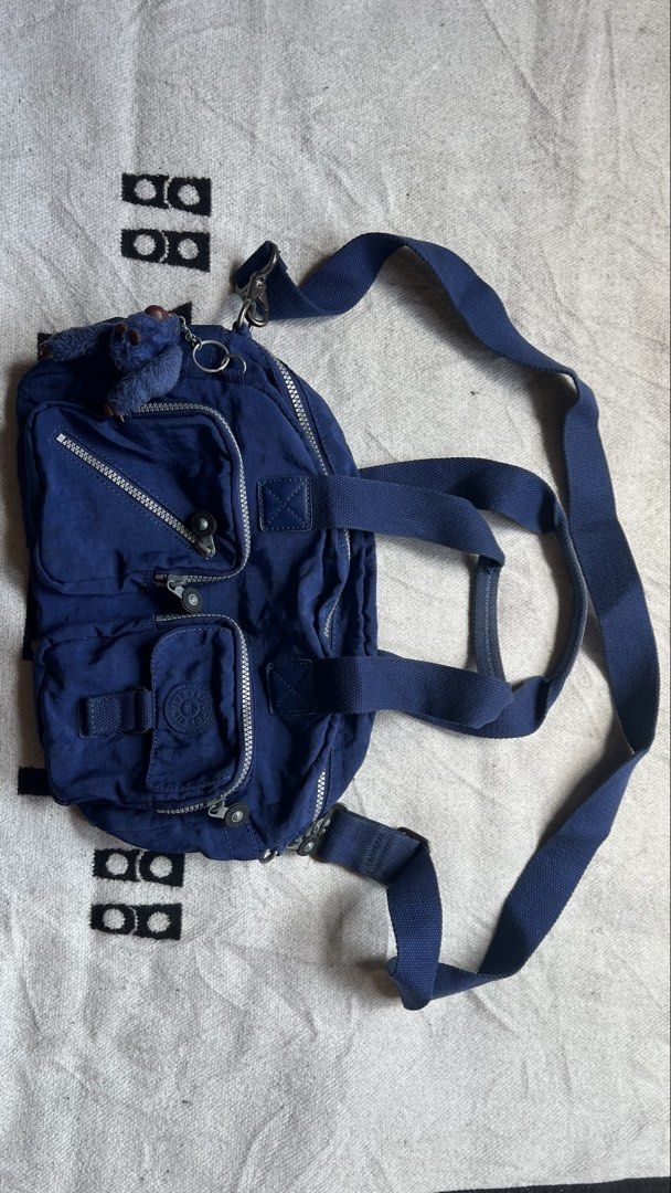 Kipling Defea Backpack Navy Blue with Monkey Charm (Category: Backpacks) located in Cagayan de Oro. Submitted by nelsondel21723 (Listing ID 1449797441, Image 1). Description: - Navy blue Kipling Defea backpack - Multiple pockets for excellent organization - Includes signature Kipling monkey charm - Adjustable straps for backpack or shoulder wear - Zippers are in great working condition - Perfect for daily use or travel.