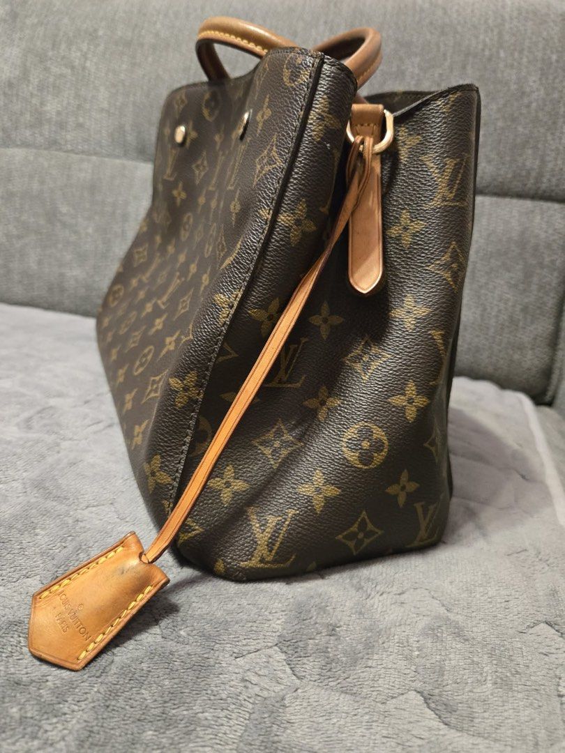 Louis Vuitton Montaigne MM Monogram (Category: Luxury Bags & Wallets) located in Manila. Submitted by prelovedyns (Listing ID 1449858019, Image 2). Description: - Louis Vuitton Montaigne MM bag - Monogram canvas with tan leather handles and trim - Includes detachable shoulder strap - Comes with original lock and keys - Spacious interior, ideal for everyday use - Shows some signs of wear on leather trim and strap.