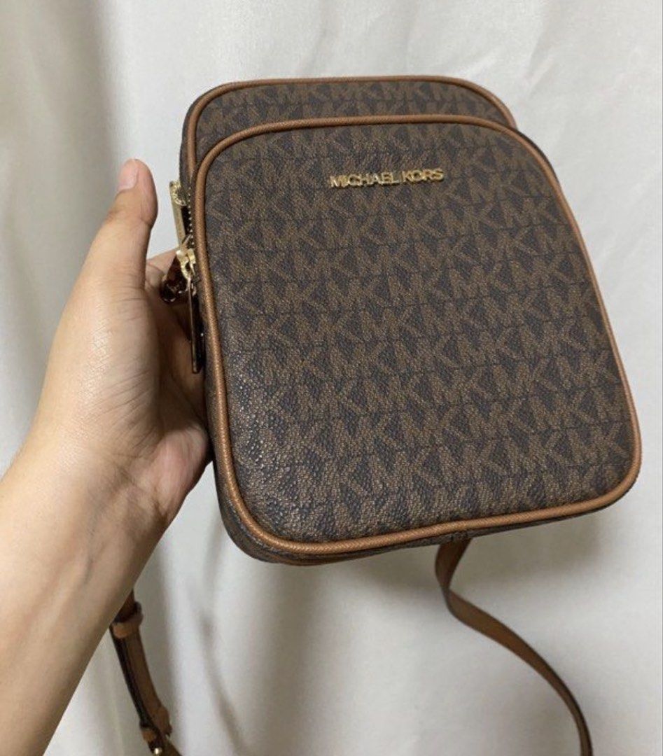 Michael Kors Monogram Crossbody Bag (Category: Luxury Bags & Wallets) located in Pakil. Submitted by anniapatri11075 (Listing ID 1449770631, Image 1). Description: - Classic brown Michael Kors crossbody bag - Signature MK monogram print - Gold hardware details - Adjustable strap for comfortable wear - Zipped compartments for secure storage - Ideal for everyday use or travel.