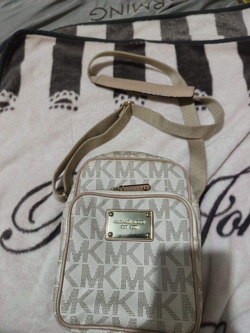 Michael Kors Monogram Crossbody Bag (Category: Luxury Bags & Wallets) located in Manila. Submitted by rochelleci78148 (Listing ID 1449948557, Image 3). Description: - Classic Michael Kors monogram pattern (white/beige) - Gold-tone hardware with MK logo plate - Secure zipper closure - Interior slip pocket for essentials - Adjustable strap for comfortable wear - Ideal for everyday use.